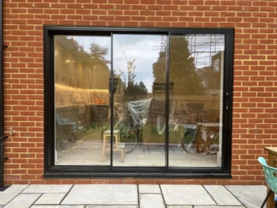 Black aluminium sliding doors in London brick rear elevation