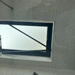 Black aluminium tilt-turn window in tiled London bathroom