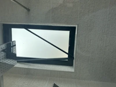Black aluminium tilt-turn window in tiled London bathroom