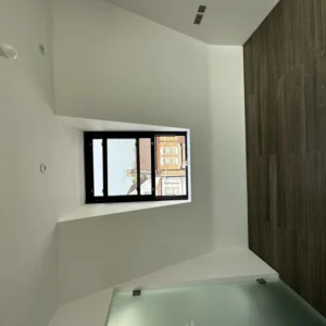 Black aluminium casement window in white London bathroom interior