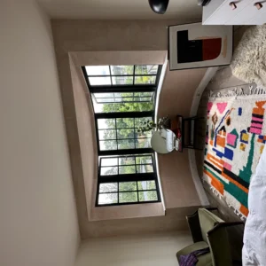 Black aluminium Crittall-style window in London bedroom