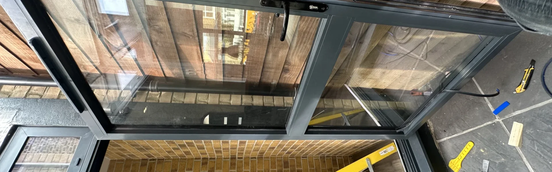 Black aluminium bifold doors onto timber deck, London home