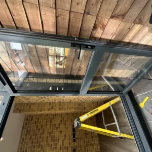 Black aluminium bifold doors onto timber deck, London home
