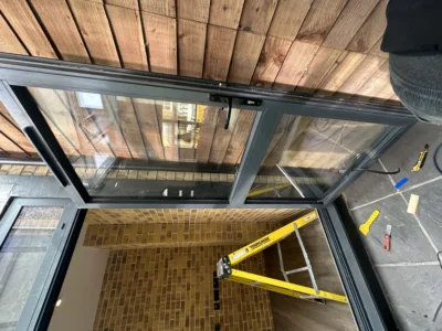 Black aluminium bifold doors onto timber deck, London home