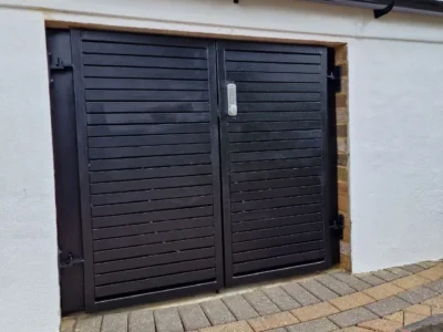 Black louvred metal garage doors London property