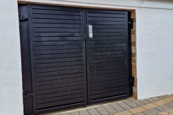 Black louvred metal garage doors London property