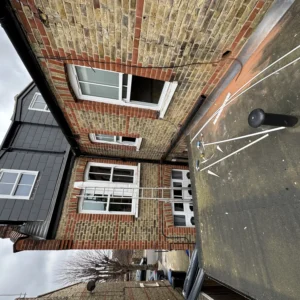 London terraced house exterior with new white uPVC windows and dormer