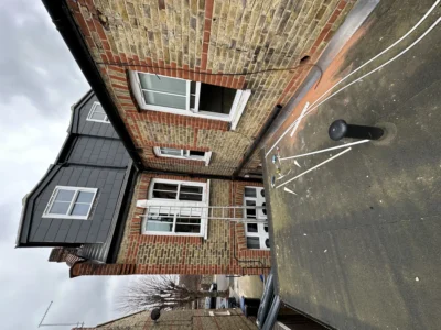 London terraced house exterior with new white uPVC windows and dormer