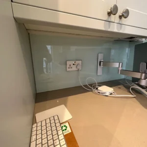 Frosted glass splashback above desk in London kitchen