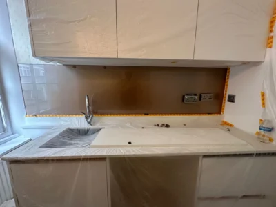 Bronze glass splashback being fitted, London kitchen