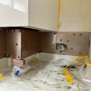 Bronze glass splashback installation detail, London kitchen