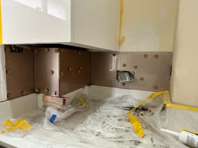 Bronze glass splashback installation detail, London kitchen