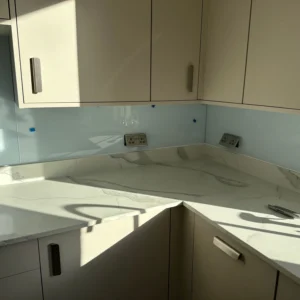 Pale blue glass splashback in modern London kitchen