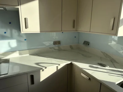 Pale blue glass splashback in modern London kitchen