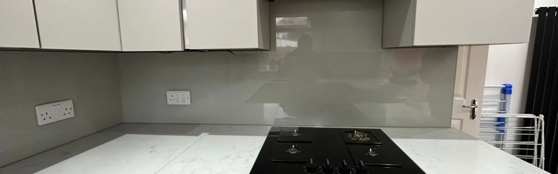 Grey glass splashback behind gas hob, London kitchen