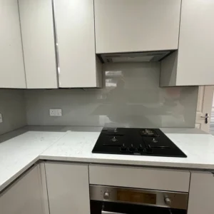 Grey glass splashback behind gas hob, London kitchen