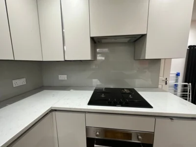 Grey glass splashback behind gas hob, London kitchen