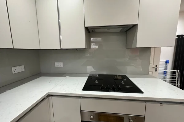 Grey glass splashback behind gas hob, London kitchen