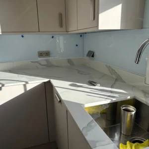 Pale blue glass splashback by kitchen sink, London