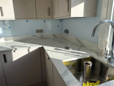 Pale blue glass splashback by kitchen sink, London