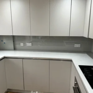 Grey glass splashback in modern London kitchen