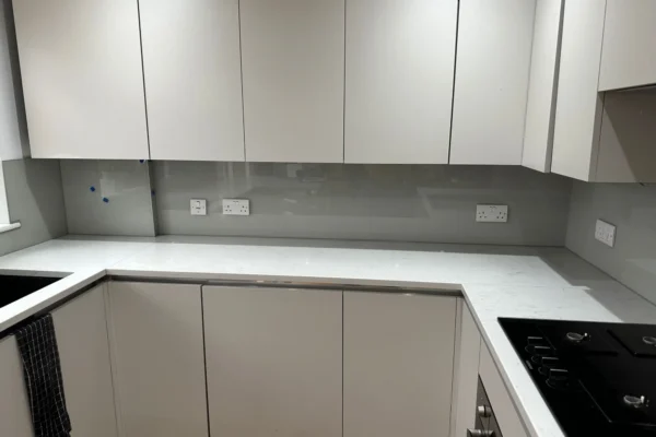 Grey glass splashback in modern London kitchen
