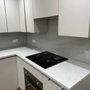 Grey glass splashback behind gas hob, London kitchen