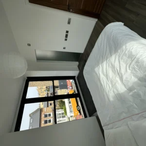 Bedroom with black aluminium window and glass balustrade, London