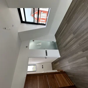 Bright stairwell with black aluminium window in London home