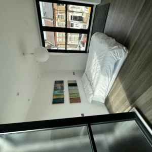 Bedroom with black aluminium window and glass balustrade, London