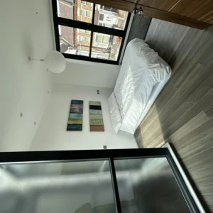 Bedroom with black aluminium window and glass balustrade, London