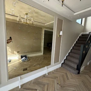 Oversized antiqued wall mirror London hallway glazing