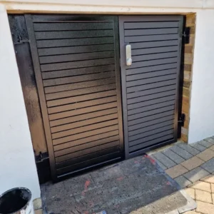 Black louvred metal garage gates London driveway