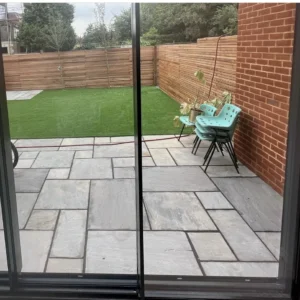 Black aluminium sliding doors onto paved London garden