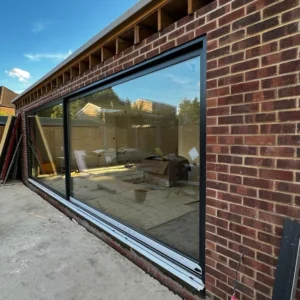 Anthracite sliding patio doors on London brick extension