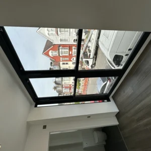 Black-framed flat rooflight over London loft conversion