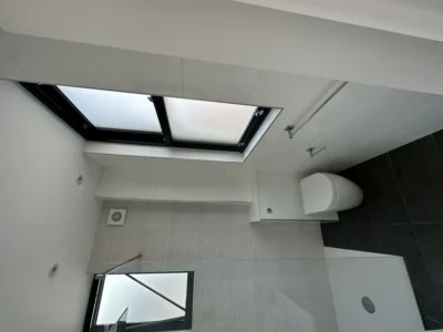Black aluminium opening rooflight in London bathroom ceiling