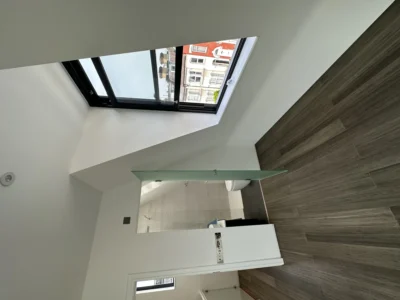 Black aluminium opening rooflight in modern London bathroom