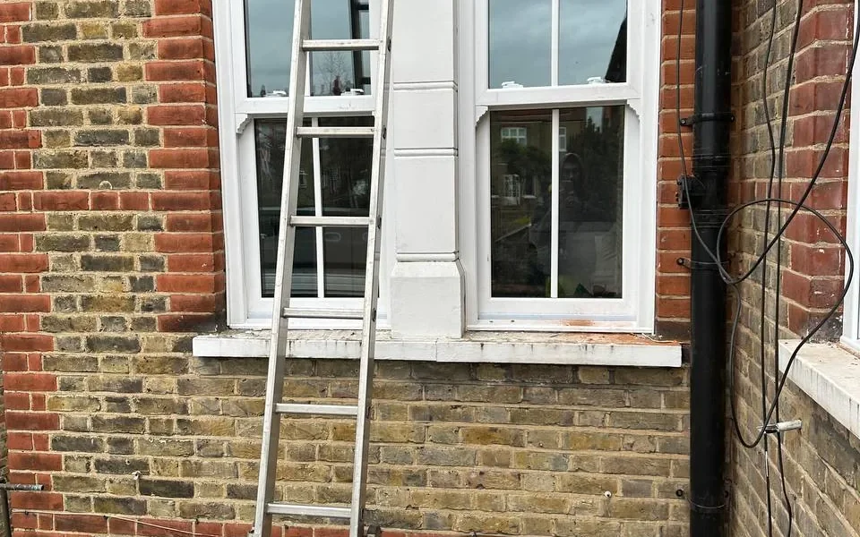 White timber sash bay window on London brick house