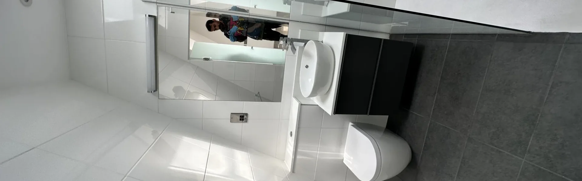 Frameless glass shower screen in modern white London bathroom
