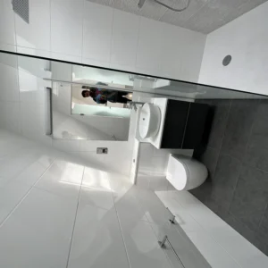 Frameless glass shower screen in modern white London bathroom