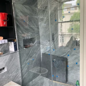 Frameless glass shower screen grey stone London bathroom