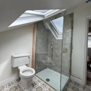 Glass shower enclosure beneath skylight, London loft bathroom