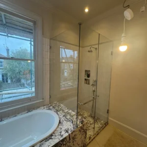 Glass shower screen beside bath, London period home