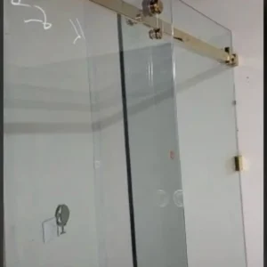 Sliding glass shower door with brass track, London