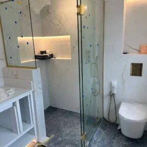 Frameless glass shower enclosure in marble bathroom, London