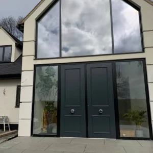Apex structural glazing around black front doors, London