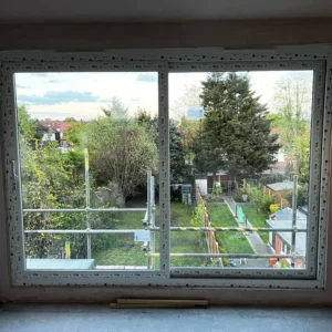 Large white uPVC window overlooking London garden during refit
