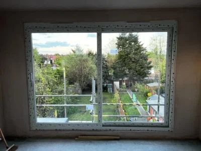 Large white uPVC window overlooking London garden during refit